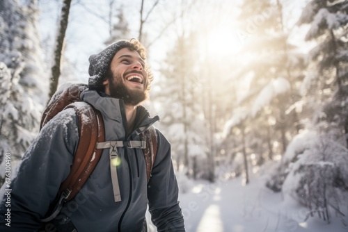 a young man hiking through a pristine winter forest, his face beaming with joy as he experiences the liberating beauty of a snowy wonderland photo