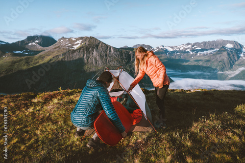 Couple friends camping in mountains, placing sleeping pad in tent. Active vacations travel outdoor in Norway, man and woman hiking together adventure family eco tourism healthy lifestyle tour