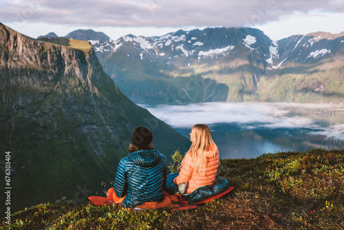 Bivouac in mountains couple man and woman in sleeping bags camping gear, travel hiking in Norway, romantic vacations outdoor friends together family active healthy lifestyle