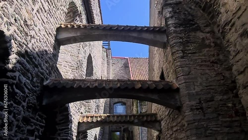 Walking on St. Katherine Passage in Old Town Tallinn, Estonia. Medieval Alley and Stone Walls photo