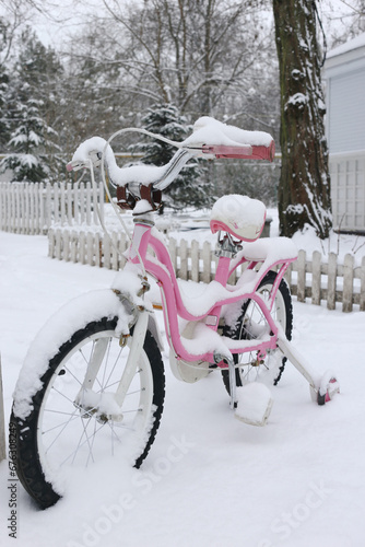 pink bicycle in the snow in the park in winter
