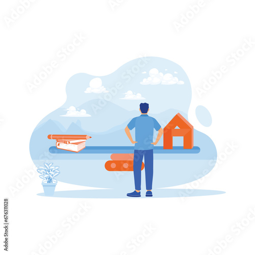 A young man with his hands on his hips stands before a wooden seesaw. Looking at the balance between notebooks and pencils with home models. House Model Balance Equilibrium concept. 