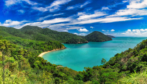 Sweeping panoramic view of a tranquil bay surrounded by lush tropical forestry