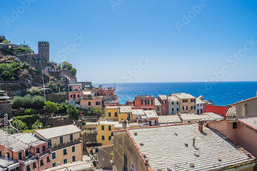 Fototapeta Naklejka Na Ścianę i Meble -  Roofs of colorful houses on hill with tower and Mediterranean sea in the background, Vernazza ITALY