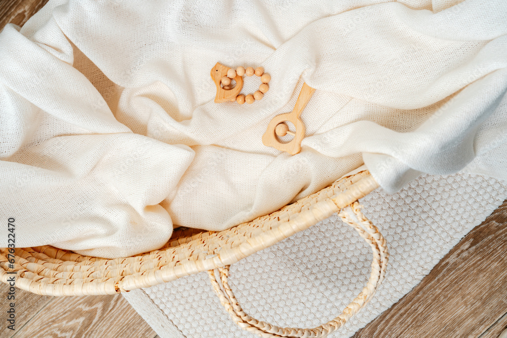 Muslin blanket and wooden toys in baby cradle Muslin blanket and wooden toys in baby cradle