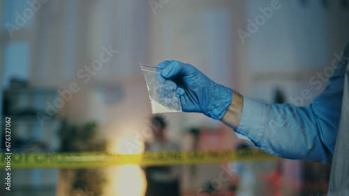A detective is examining an illegal substance found at the crime scene during a police raid
