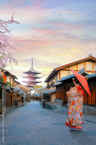 Young Japanese woman in traditional Kimono dress with Yasaka Pagoda at Hokanji temple in Kyoto, Japan during full bloom cherry blossom in spring