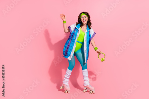 Photo of sporty lady trainer ride roller skates listen sport playlist with headset isolated pastel color background