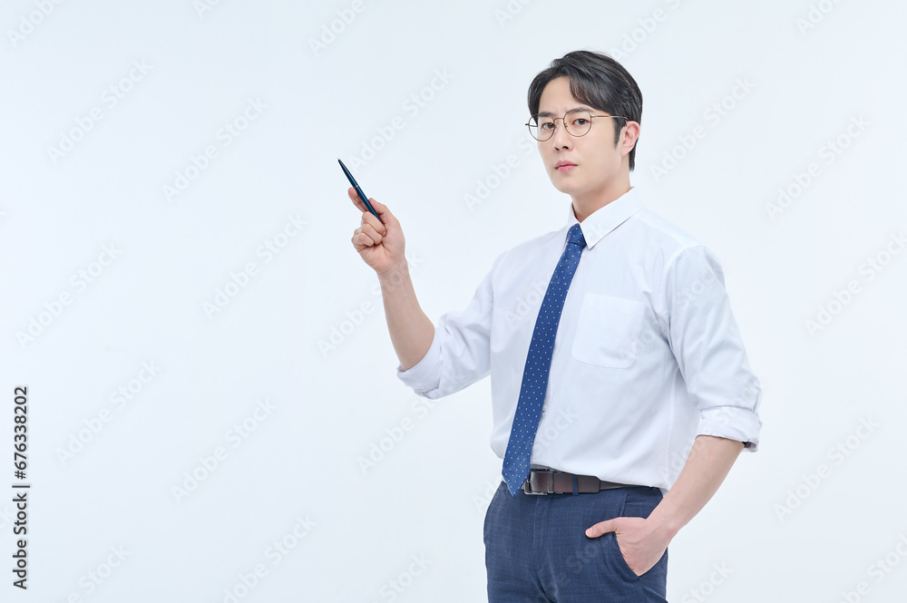 A young, handsome Asian man wearing glasses and a dress shirt and tie is holding a pen and explaining about business. A young, handsome Asian man wearing glasses and a dress shirt and tie is holding a pen and explaining about business.