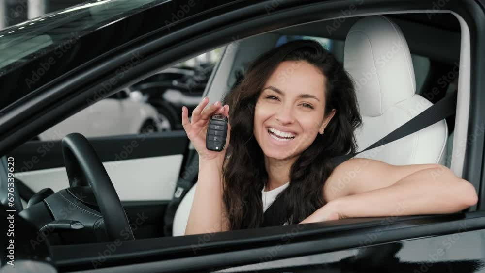 Happy young woman sitting in the car and holding key. Slow motion Happy young woman sitting in the car and holding key. Slow motion