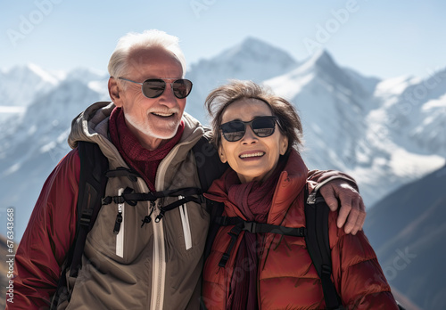 pareja mayor de 50 años haciendo senderismo entre montañas nevadas , Concepto de viajes y actividades para seniors