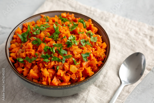 Homemade Smoky Spiced Carrot Rice with Parsley in a Bowl, side view.