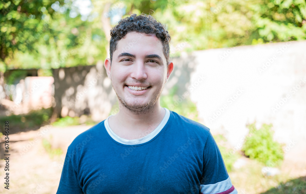 Portrait of Latin American man looking and smiling at the camera. Portrait of cheerful young latin guy smiling at camera outdoors Portrait of Latin American man looking and smiling at the camera. Portrait of cheerful young latin guy smiling at camera outdoors