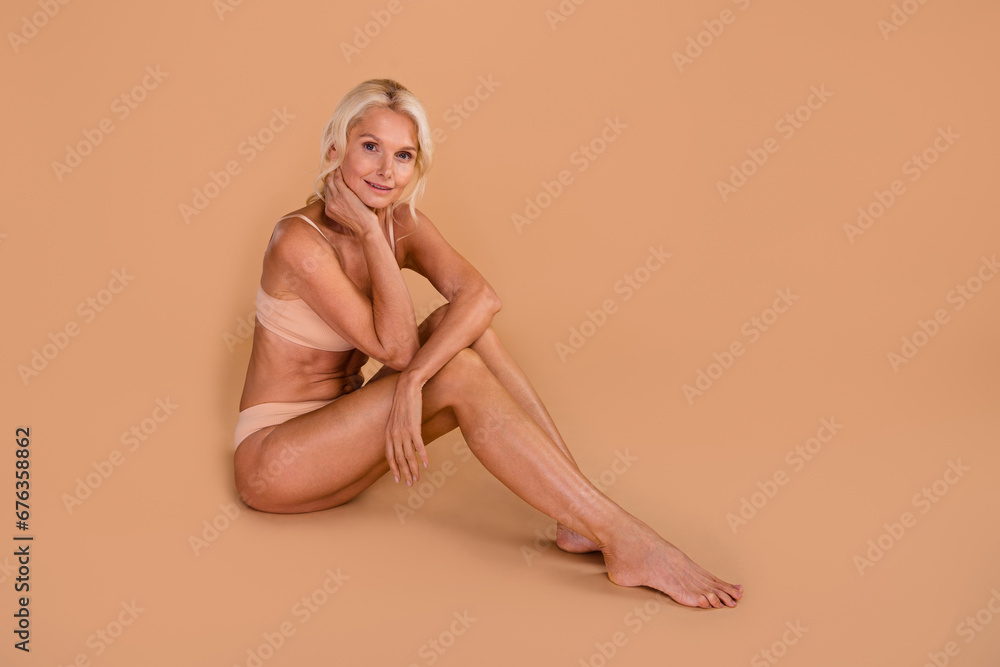 Full body profile photo of attractive gorgeous barefoot person sit floor empty space isolated on beige color background Full body profile photo of attractive gorgeous barefoot person sit floor empty space isolated on beige color background
