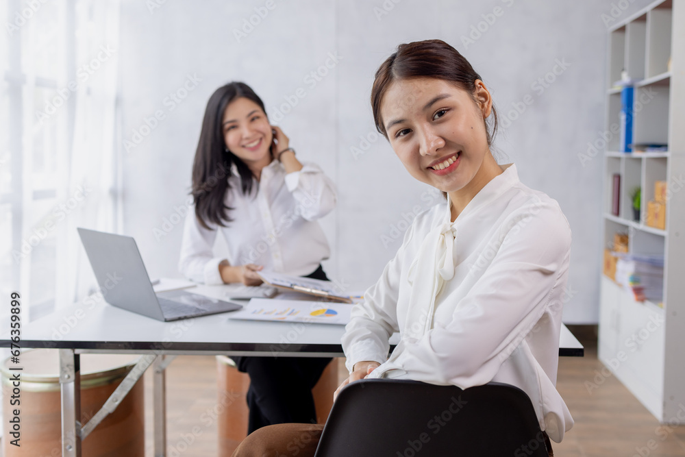 Two asian confident business women point to graphs and charts to analyze market data, balance sheet, account, net profit to plan new sales strategies to increase production capacity. Two asian confident business women point to graphs and charts to analyze market data, balance sheet, account, net profit to plan new sales strategies to increase production capacity.
