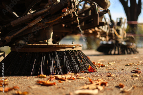 Obraz na płótnie Cleaning the alleys in a park of a lot of fallen autumn leaves on the asphalt. Close up photo with a street utility car machine used to clean the public parks. w salonie