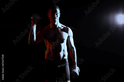 Handsome young fitness sporty strong guy bare-chested muscular sportsman on studio background