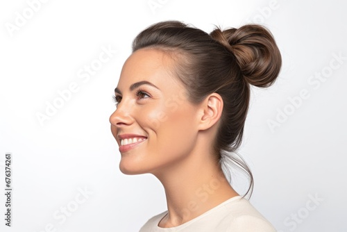 Young beautiful brunette woman with short hair and toothy smile on white background, close up profile portrait.