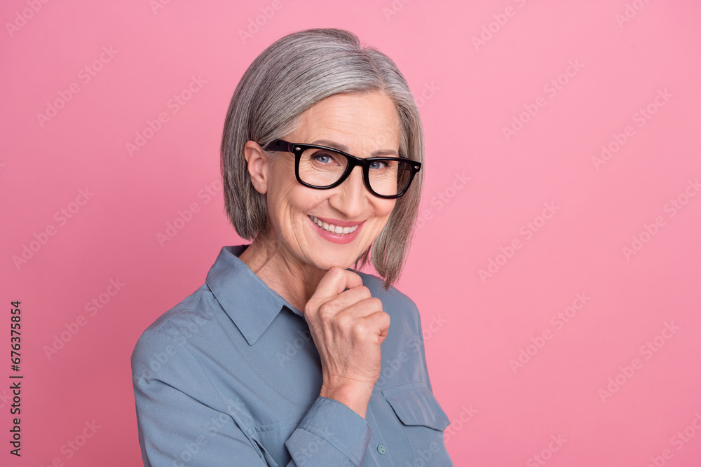 Photo of gorgeous positive retired lady wear trendy clothes spectacles arm touch face hmm decision isolated on pink color background