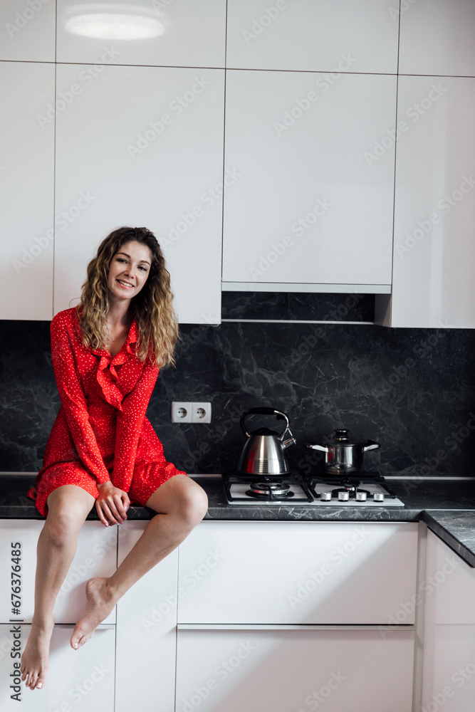 Woman sitting on kitchen table in kitchen Woman sitting on kitchen table in kitchen