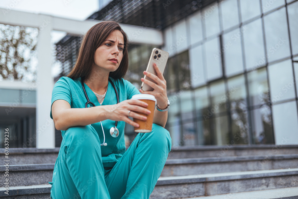 Shot of a female nurse looking stressed while sitting on a staircase ...