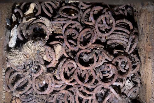 Old and rusty chain metal hoops in rotting vintage wooden box