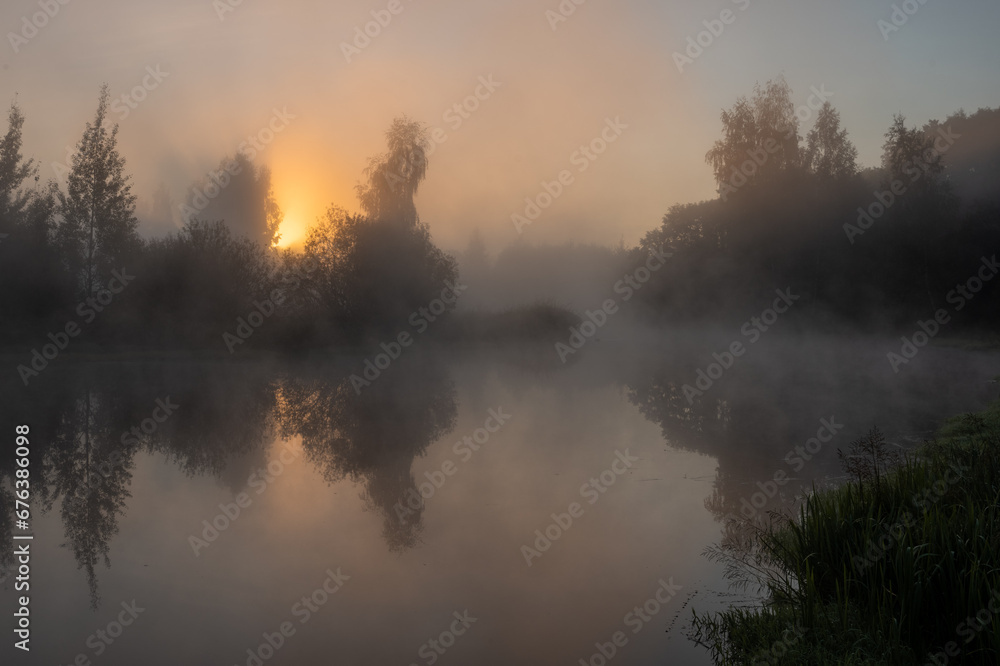 Dawn over a foggy river