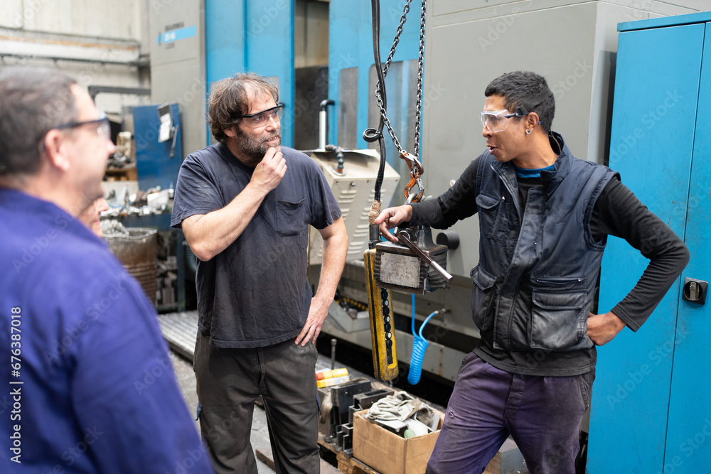 Coworkers talking in manufacture factory Coworkers talking in manufacture factory