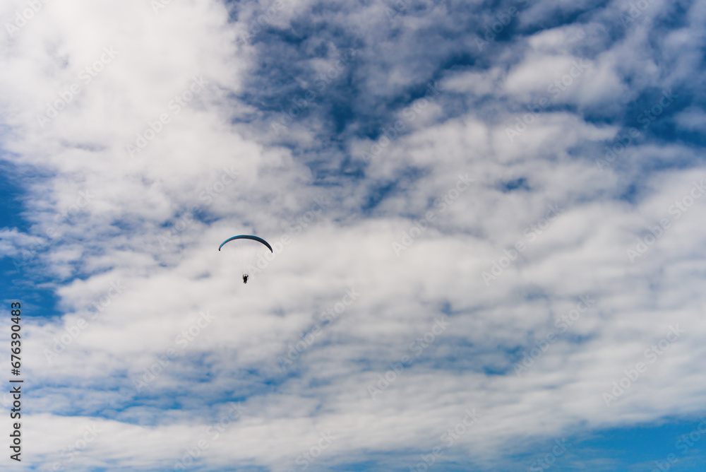 Floating paraglider in the sky with clouds in the mountains Floating paraglider in the sky with clouds in the mountains
