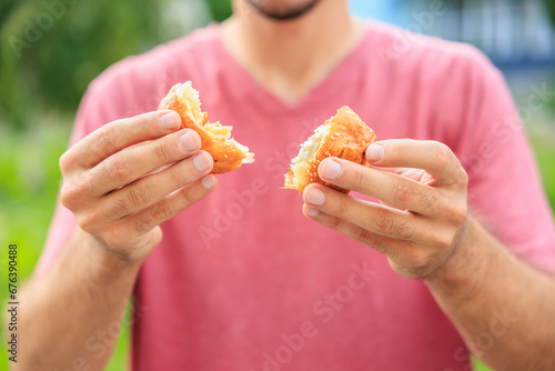 A guy's hand holds a mini puff pastry with cheese, snack and fast food concept. Selective focus on hands