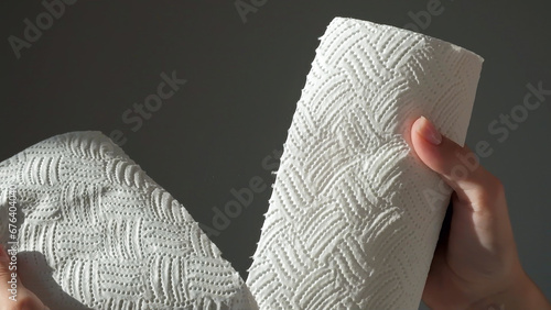 Female hands tear off piece of white paper towel from a roll photo