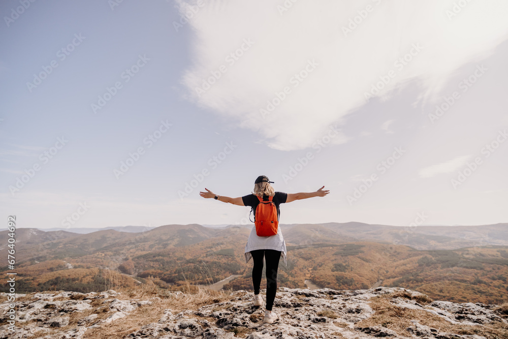woman backpack on mountain peak looking in beautiful mountain valley in autumn. Landscape with sporty young woman, blu sky in fall. Hiking. Nature woman backpack on mountain peak looking in beautiful mountain valley in autumn. Landscape with sporty young woman, blu sky in fall. Hiking. Nature