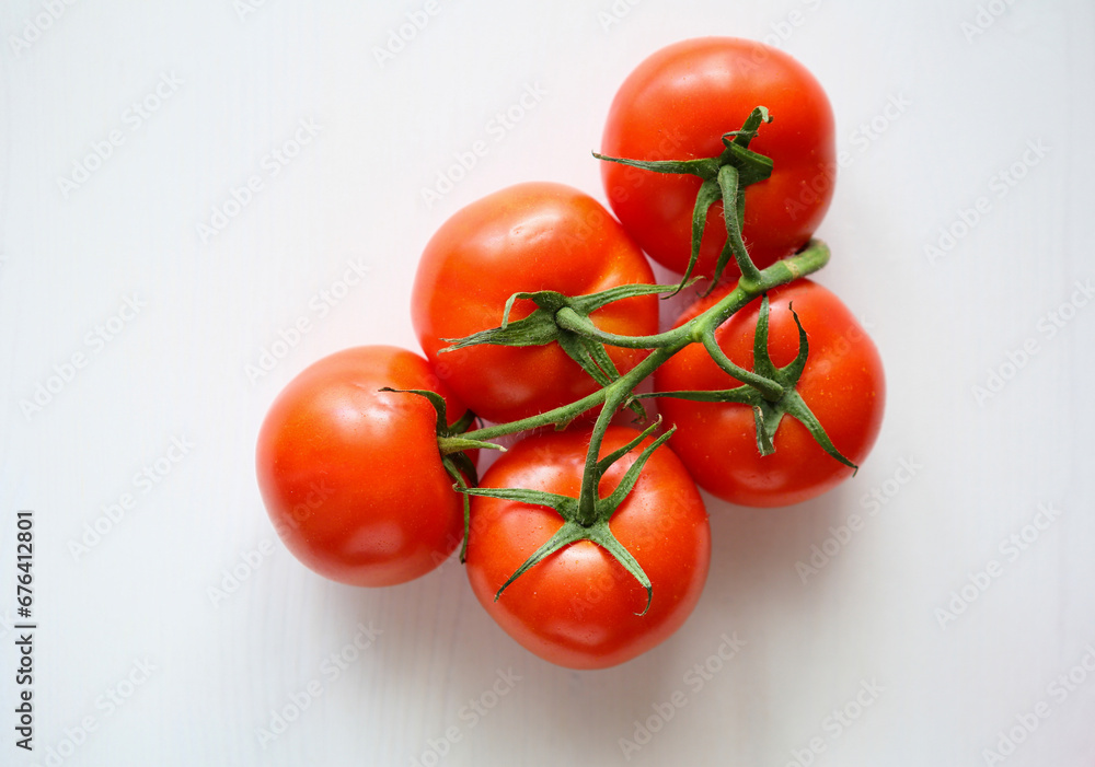 ripe tomatoes on branch on white surface ripe tomatoes on branch on white surface