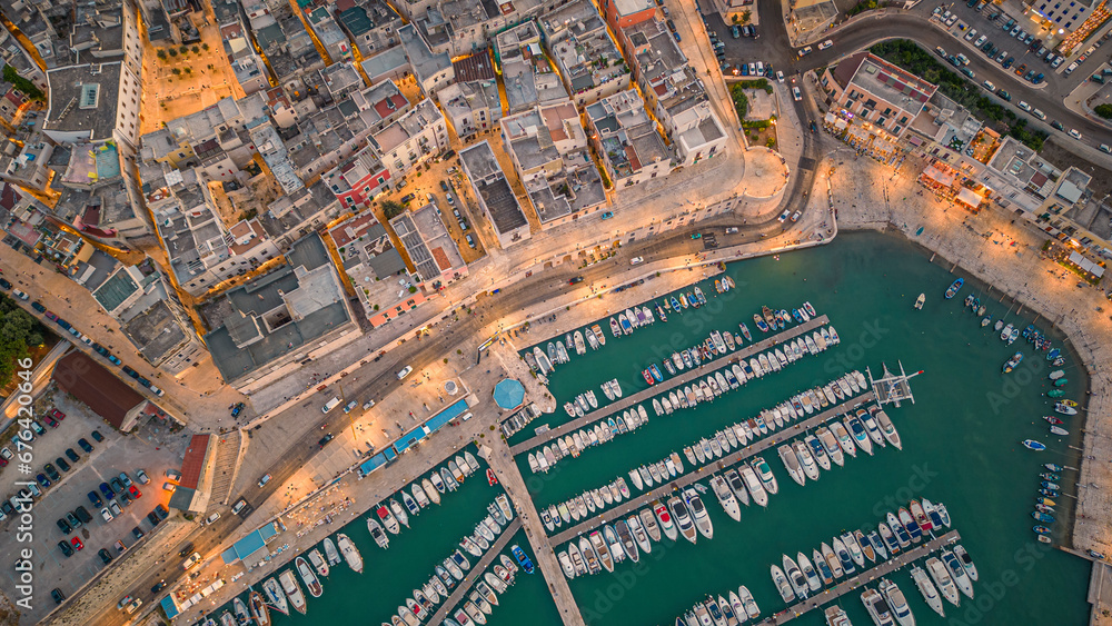 Fototapeta premium Aerial view of seafront and old town Bisceglie in Puglia with drone on sunset.