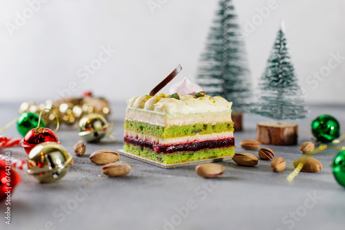 Pistachio cake slice with christmas decoration background.