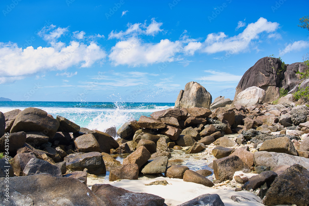 Sunny, white sandy beach, huge granite rocks at port glaud beach, Mahe, Seychelles