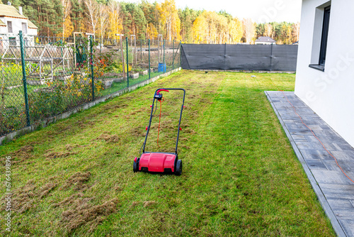 Foto Scarifying the lawn before the winter season using an electric scarifier