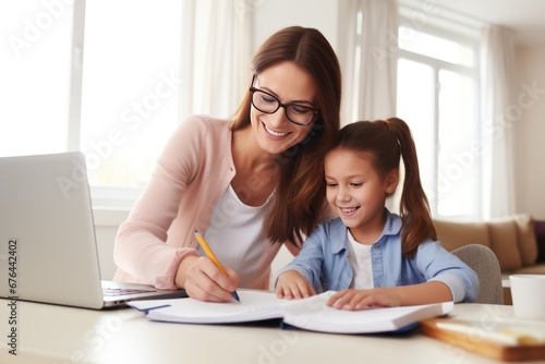 Mom helps daughter do homework sitting at table writing in paper notebook right answer