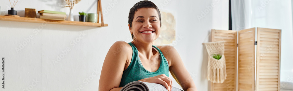jolly woman in sportswear smiling at camera with fitness mat in hands, fitness and sport, banner jolly woman in sportswear smiling at camera with fitness mat in hands, fitness and sport, banner