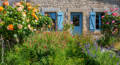 Fototapeta Naklejka Na Ścianę i Meble -  Petit jardin fleuri au pied d'une charmante maison en Bretagne.