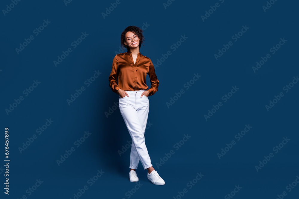 Full length photo of cute adorable woman dressed brown silk shirt walking empty space isolated blue color background Full length photo of cute adorable woman dressed brown silk shirt walking empty space isolated blue color background