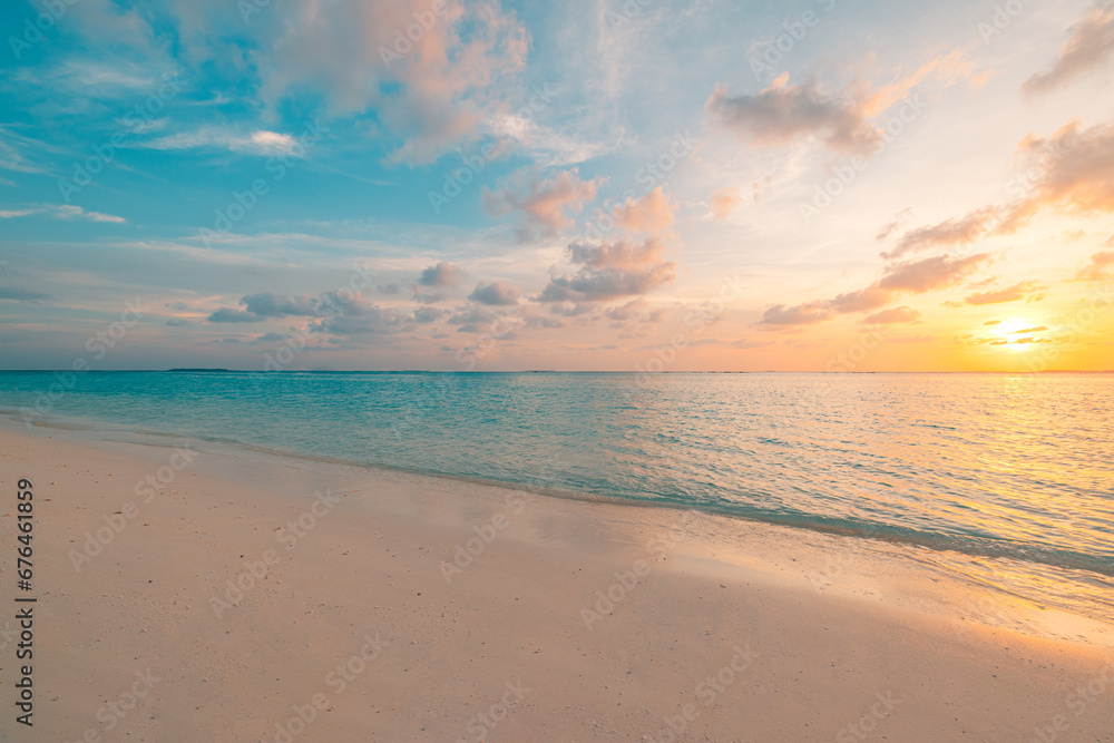 Beautiful sunset horizon sea or ocean. Vibrant soft colors magic sunlight. Small clouds yellow golden sky, reflection of sun water sand on beach. Peaceful romantic vacation in tropical island paradise