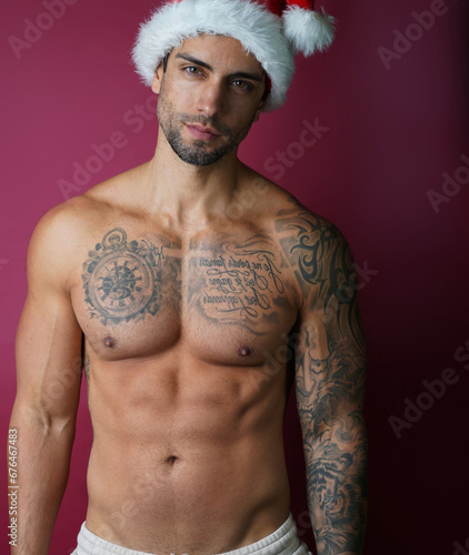Handsome muscular male model with santa hat