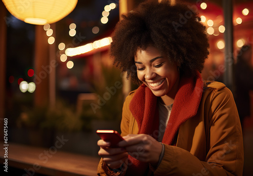 Young woman looking at cell phone at night bokeh lighting winter holiday 