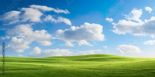 Grassy hills under blue sky with clouds photo