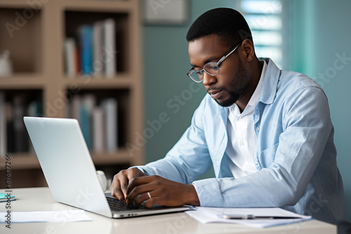 Black man with disability checking his medical documents and filling form on laptop photo