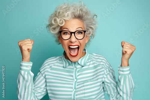 Elderly exultant overjoyed jubilant woman 50s years old wear light striped shirt look camera spread hands say wow isolated on plain pastel blue cyan color background studio portrait Lifestyle concept photo