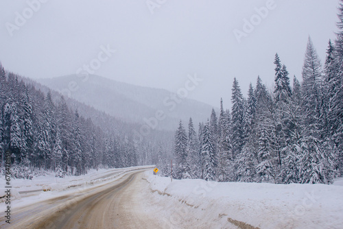 Steep highway among snow-capped mountains on a cloudy winter day. American highways