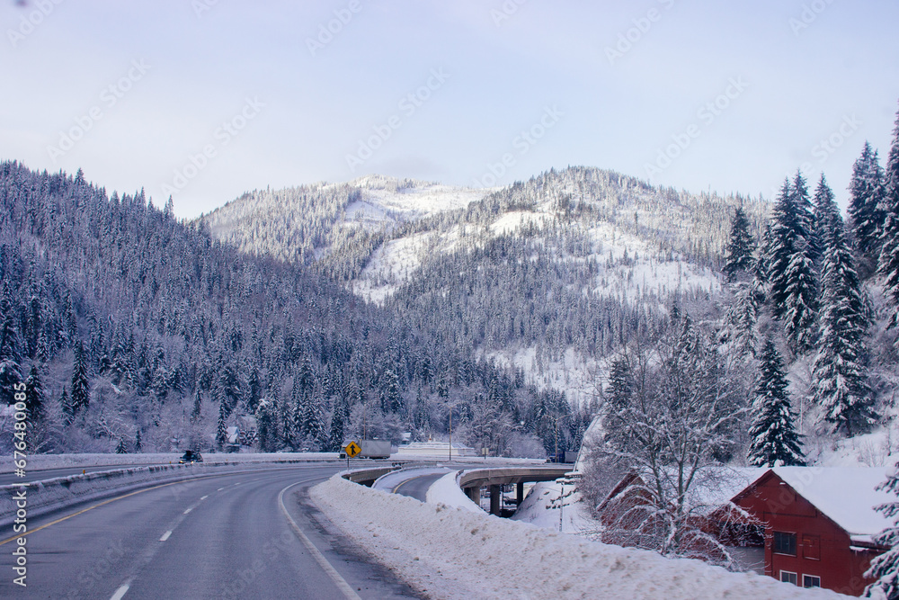 Steep highway among snow-capped mountains on a cloudy winter day. American highways