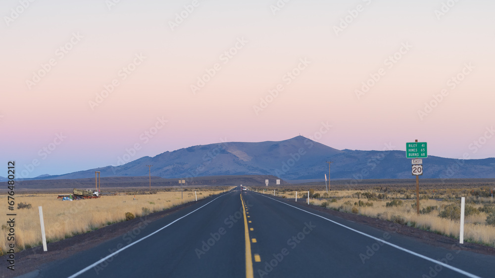 Long straight stretch of US highway 20 in central Oregon High Desert at dusk